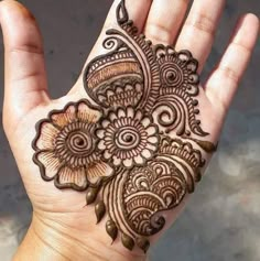 the hand is decorated with henna and flowers on it's palm, as well as an intricate design