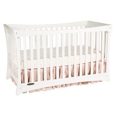 a white crib with pink ruffles on the bottom and side rails, in front of a white background