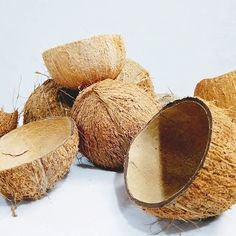 some coconuts that are cut in half on a white surface