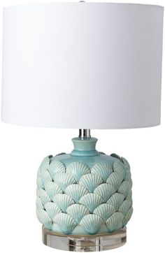 a table lamp with a white shade on the base and a light blue shell design