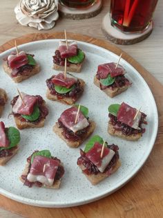 small appetizers are arranged on a plate with toothpicks stuck in them