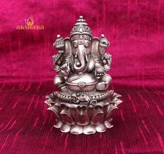 an elephant statue sitting on top of a red velvet covered surface with the words akshana above it