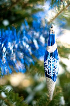 a blue ornament hanging from a christmas tree