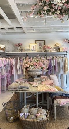 a room filled with lots of clothes and baskets on top of the floor next to a table