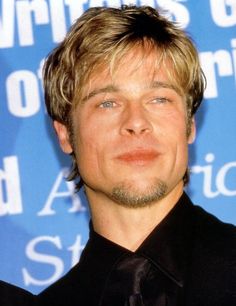 a close up of a person wearing a black shirt and tie