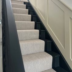 the stairs are lined with black and white carpet