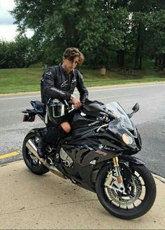 a man sitting on top of a black motorcycle