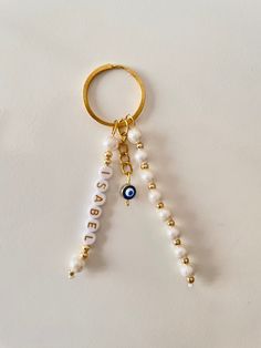 a keychain with beads hanging from it's side on a white surface