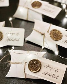 wedding place cards with waxed seals and twine on them are sitting on a table