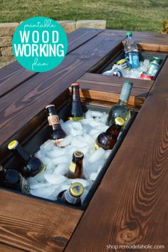 an outdoor table with ice and beer bottles in it