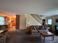 a living room filled with furniture and a stair case