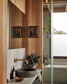 a bathroom with wood paneling and marble counter tops, along with a large tub