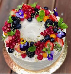 a cake decorated with fresh fruit and flowers