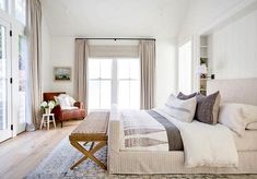 a bedroom with a large bed and white walls