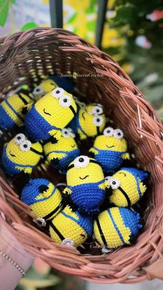 a basket filled with small yellow and blue crocheted minion toys sitting on top of a table