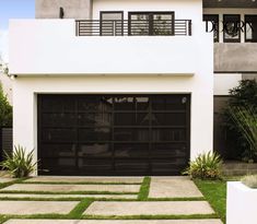 a white house with a black garage door