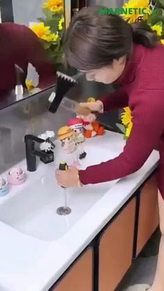 a woman is washing her hands in the sink