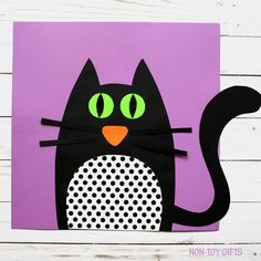 a paper cut out of a black cat with green eyes