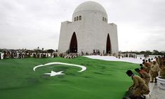 people standing in front of a building with a large flag on it's side