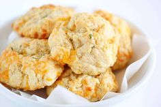 a white bowl filled with biscuits covered in cheese