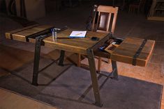 a wooden table sitting on top of a hard wood floor next to a metal chair