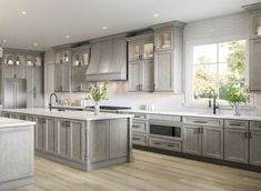 a large kitchen with gray cabinets and white counter tops, along with an island in the middle