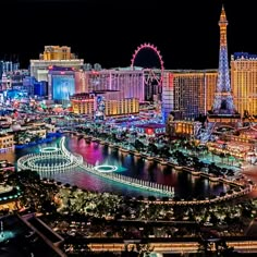 the las vegas strip at night is lit up with colorful lights and ferris wheel in the background