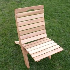 a wooden lawn chair sitting in the grass