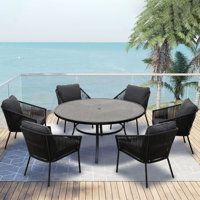 an outdoor table and chairs on a deck overlooking the ocean