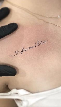 the back of a woman's stomach with her name written on it and black gloves