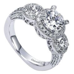 a white gold engagement ring with an oval center surrounded by round diamonds