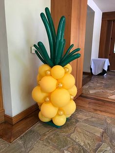 a large balloon pineapple sitting on top of a stone floor next to a doorway