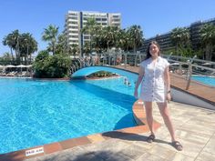 a woman standing in front of a swimming pool