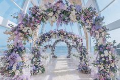 an outdoor ceremony setup with flowers on the aisle and chairs in front of the ocean