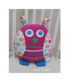 a stuffed owl sitting on top of a white chair next to a wooden fence with polka dots