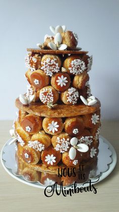 a three tiered cake is decorated with white and brown icing flowers on it