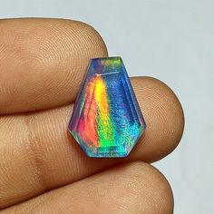 a rainbow colored ring sitting on top of a finger