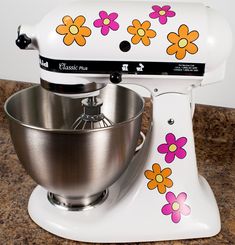 a white mixer with flowers painted on it