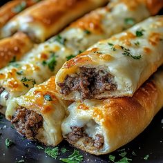 two pieces of bread with meat and cheese on it sitting on a black plate next to some parsley