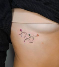 a woman's stomach with an embroidered flower on it and the word love spelled in small letters