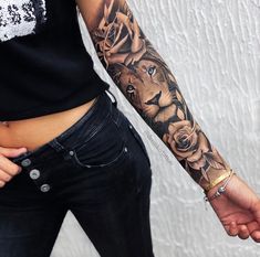 a woman with a lion tattoo on her arm holding the hand of a man in jeans