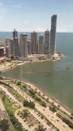 an aerial view of a large city next to the ocean with cars driving on it