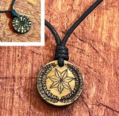 a wooden pendant with a star on it and a leather cord attached to the necklace