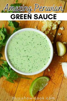 an image of green sauce in a bowl with limes and garlic on the side