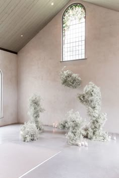 an artistic display in the middle of a room with candles on the floor and trees growing out of it