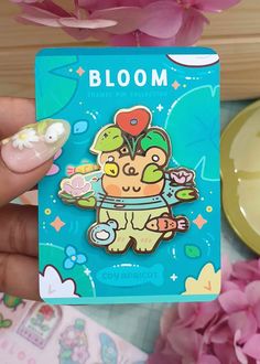 a person holding up a small card with a flower in the center and a sticker on it