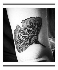 a black and white photo of a woman's arm with a tattoo on it