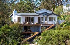 a white house sitting on top of a lush green hillside