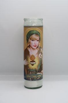 a candle with a painting of a woman holding a sunflower in her right hand