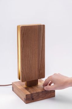 a wooden lamp with a person's hand on it